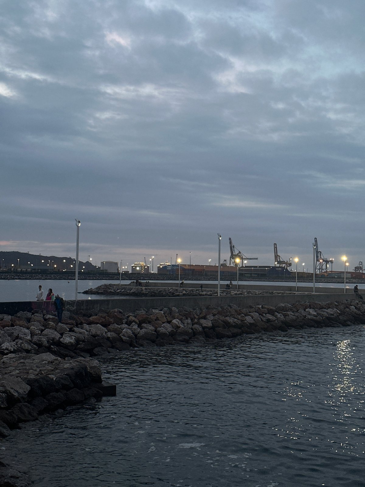Evening scenes captured at Gijón port and beach under overcast skies