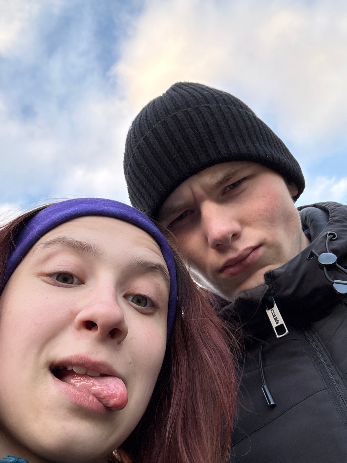 Two friends pose playfully around Perm bus stop and park