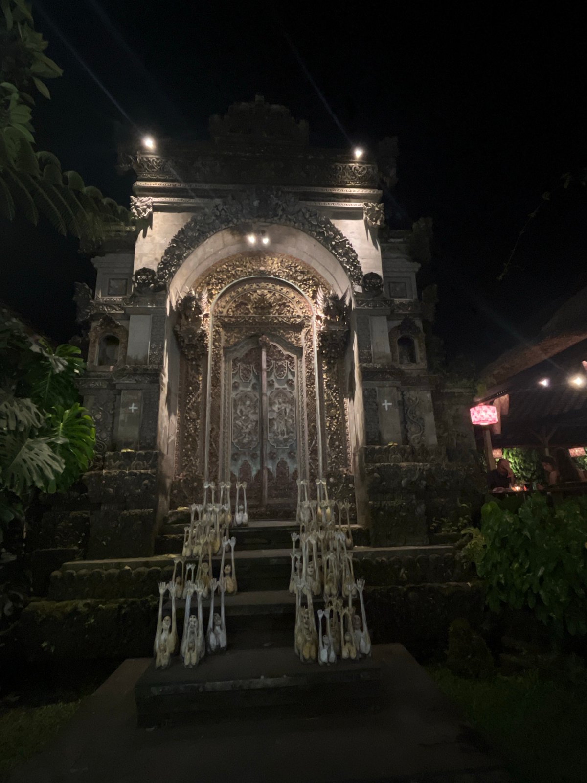 Ornate Balinese temple entrance glowing under night lights