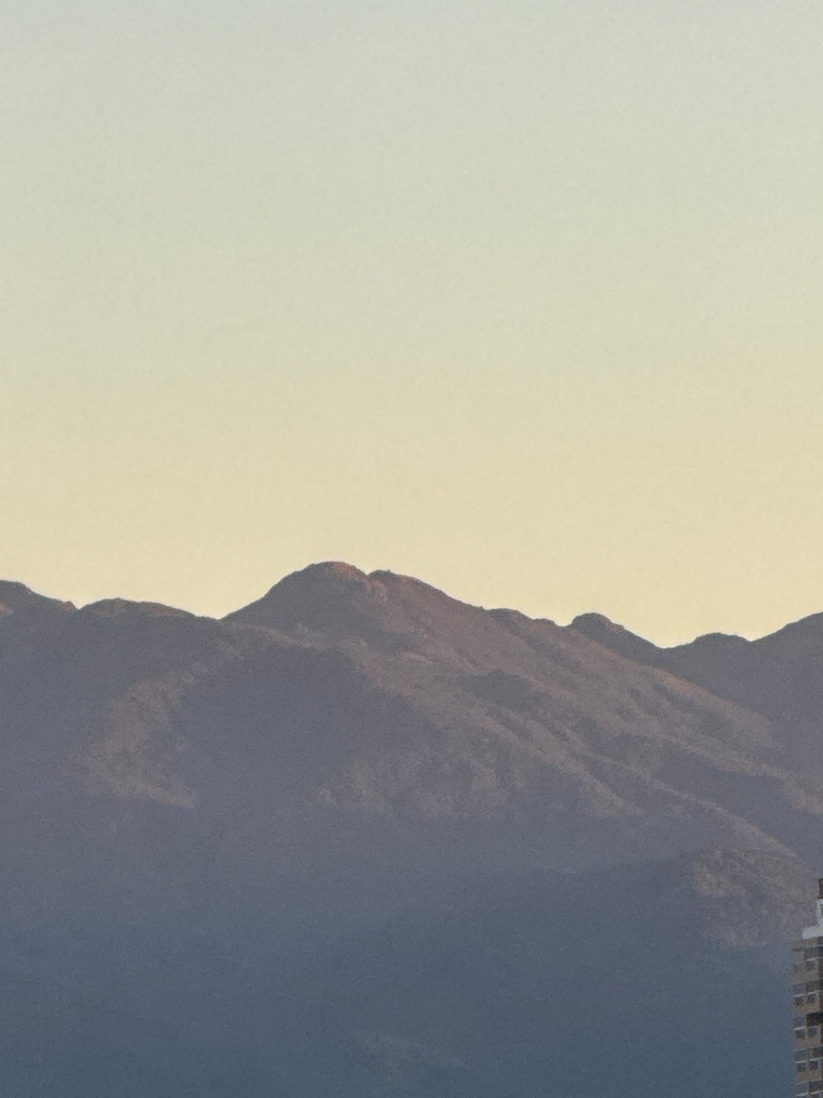 Silhouetted mountain range at dusk, warm horizon glow
