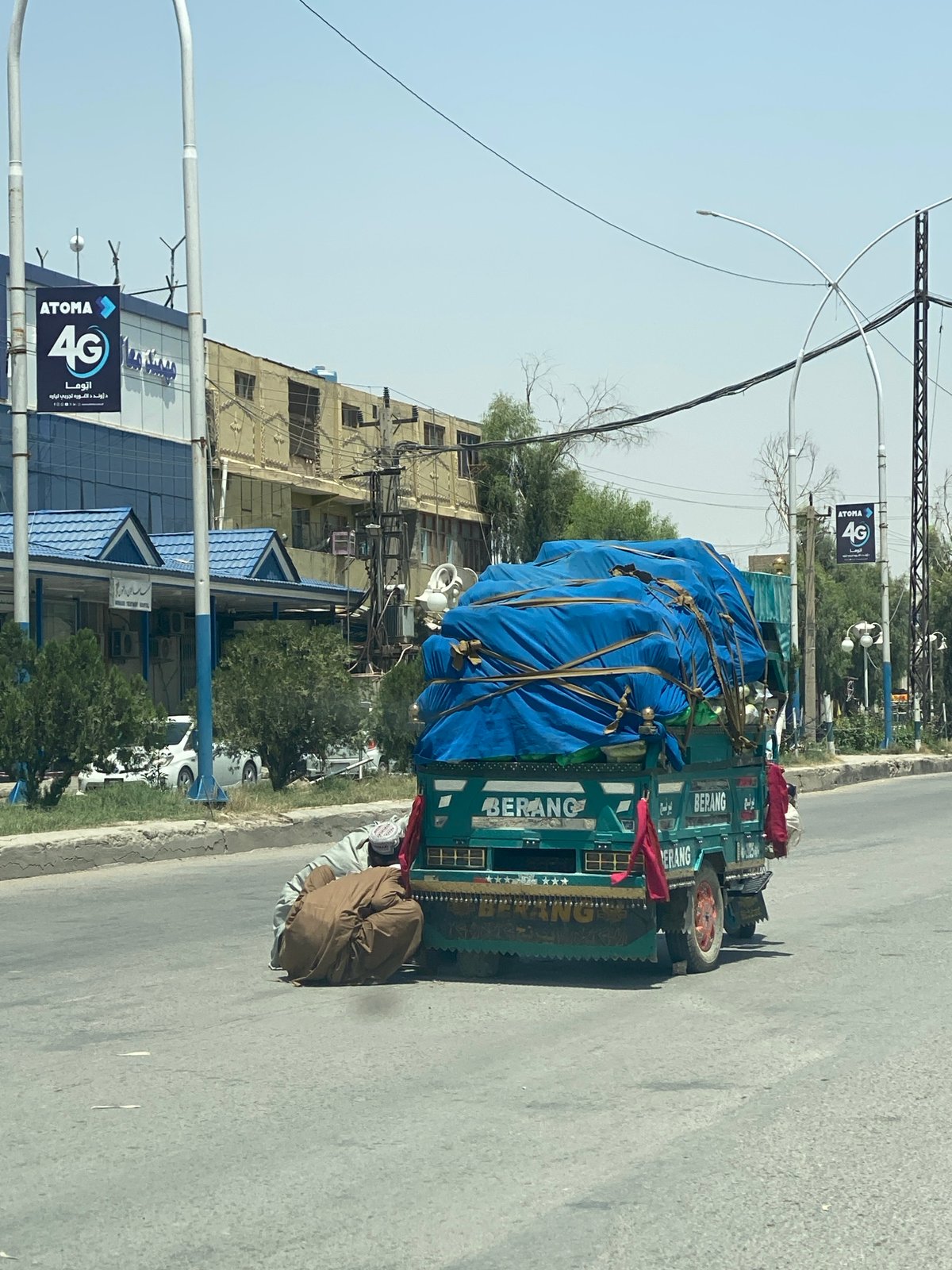 Teal cargo truck parked roadside in Kandahar, Afghanistan