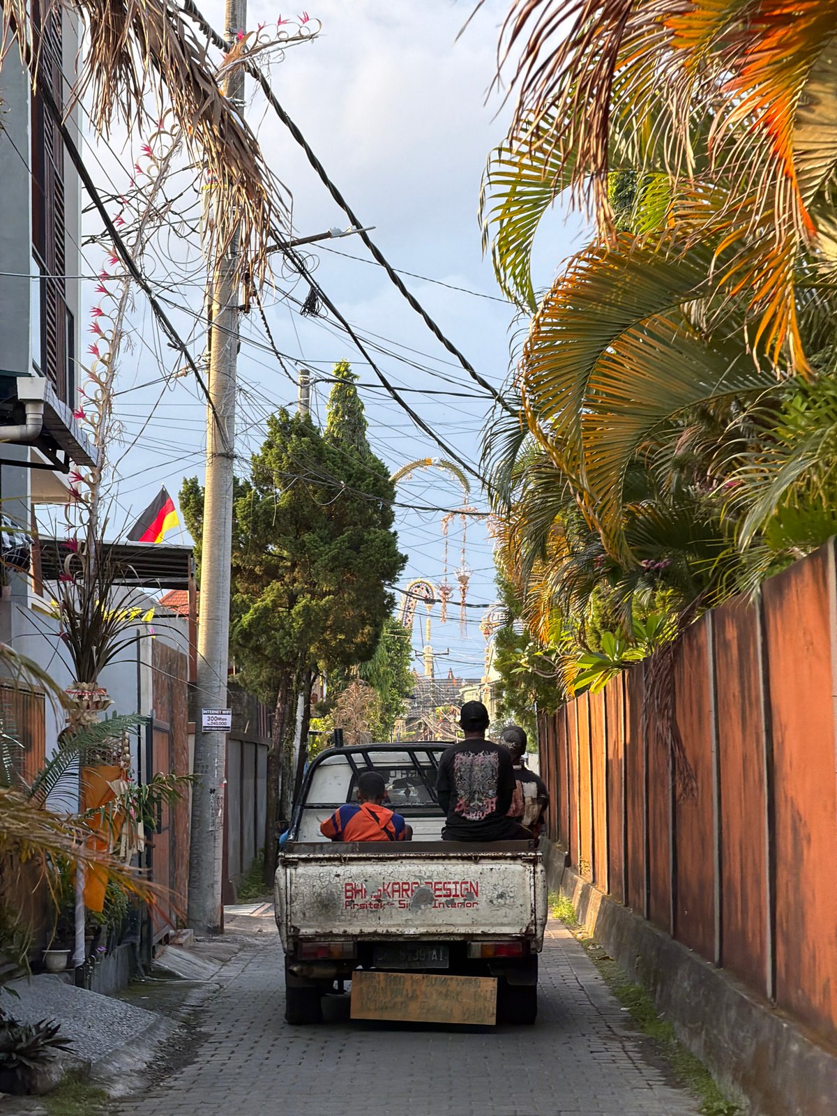White pickup truck with passengers rolls through North Kuta streets