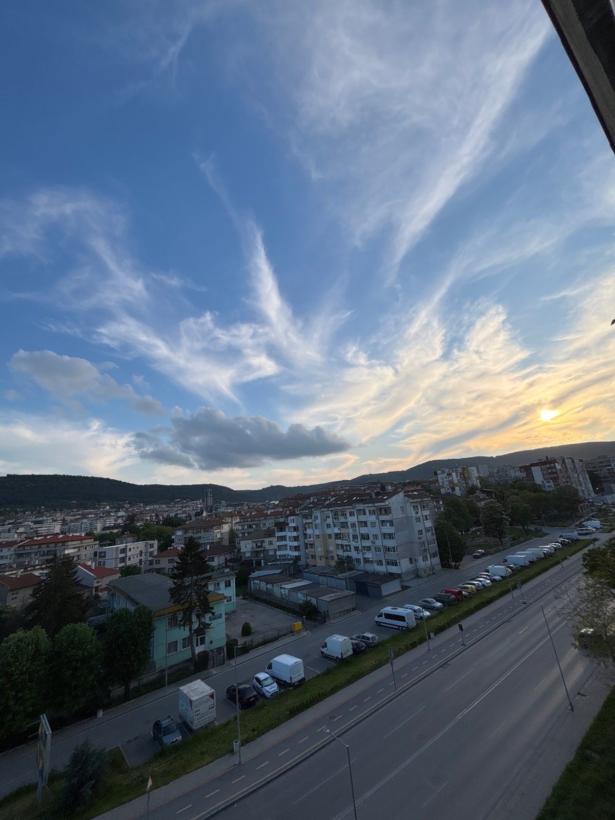 Photographer documents city sunset with DSLR camera from elevated viewpoint