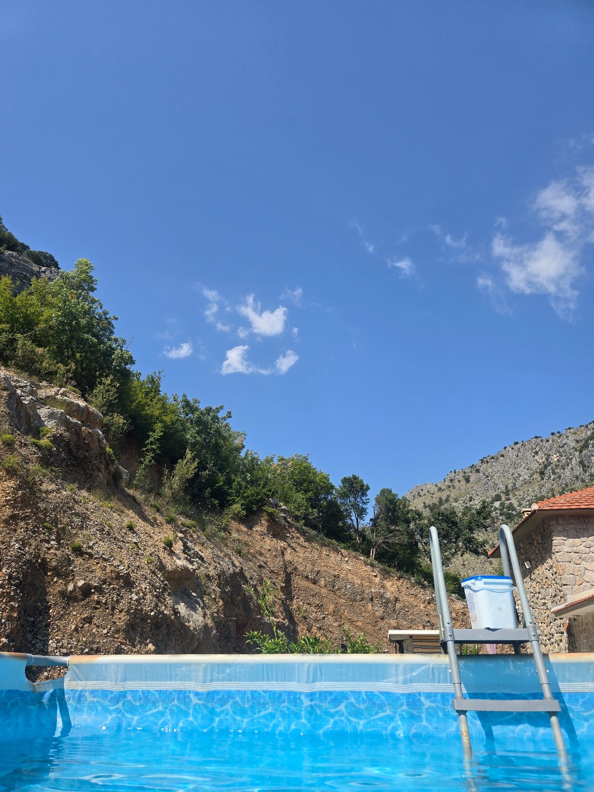 Mountain-backed pool, inside and out on a sunny afternoon