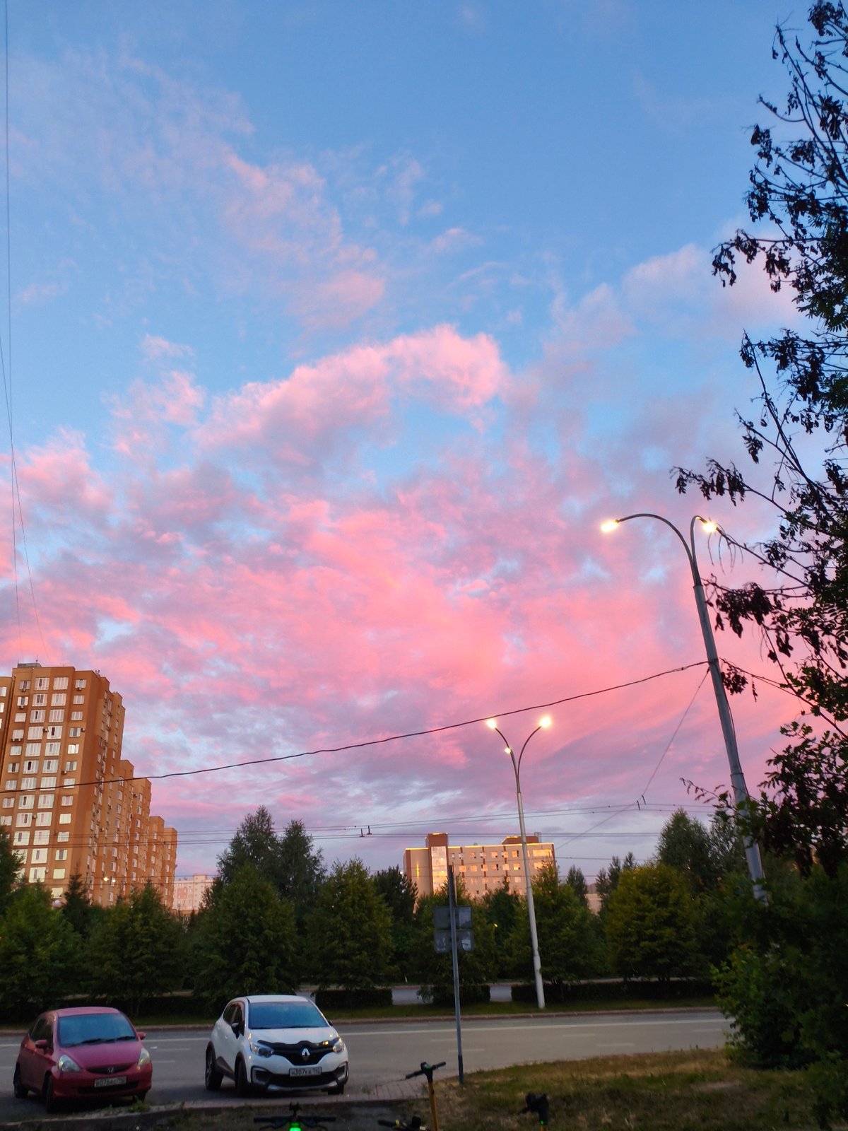 Kemerovo street at sunset, pink clouds over evening traffic