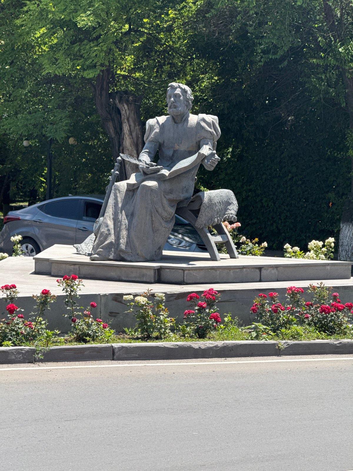 Stone monument of a robed, book-reading figure in Armenia