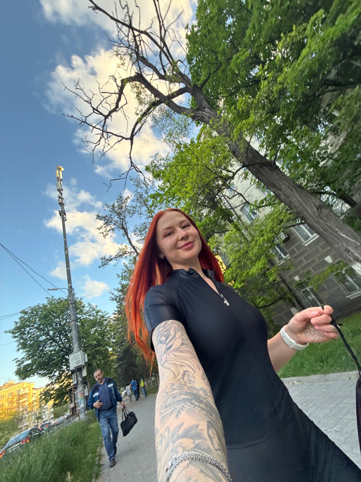 Tattooed woman takes selfies on Rostov-on-Don sidewalk
