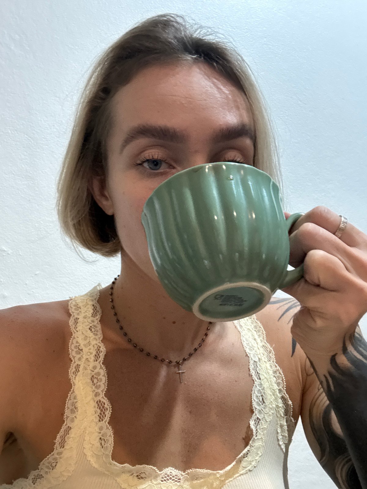 Woman drinks from green mug in Karon, Thailand