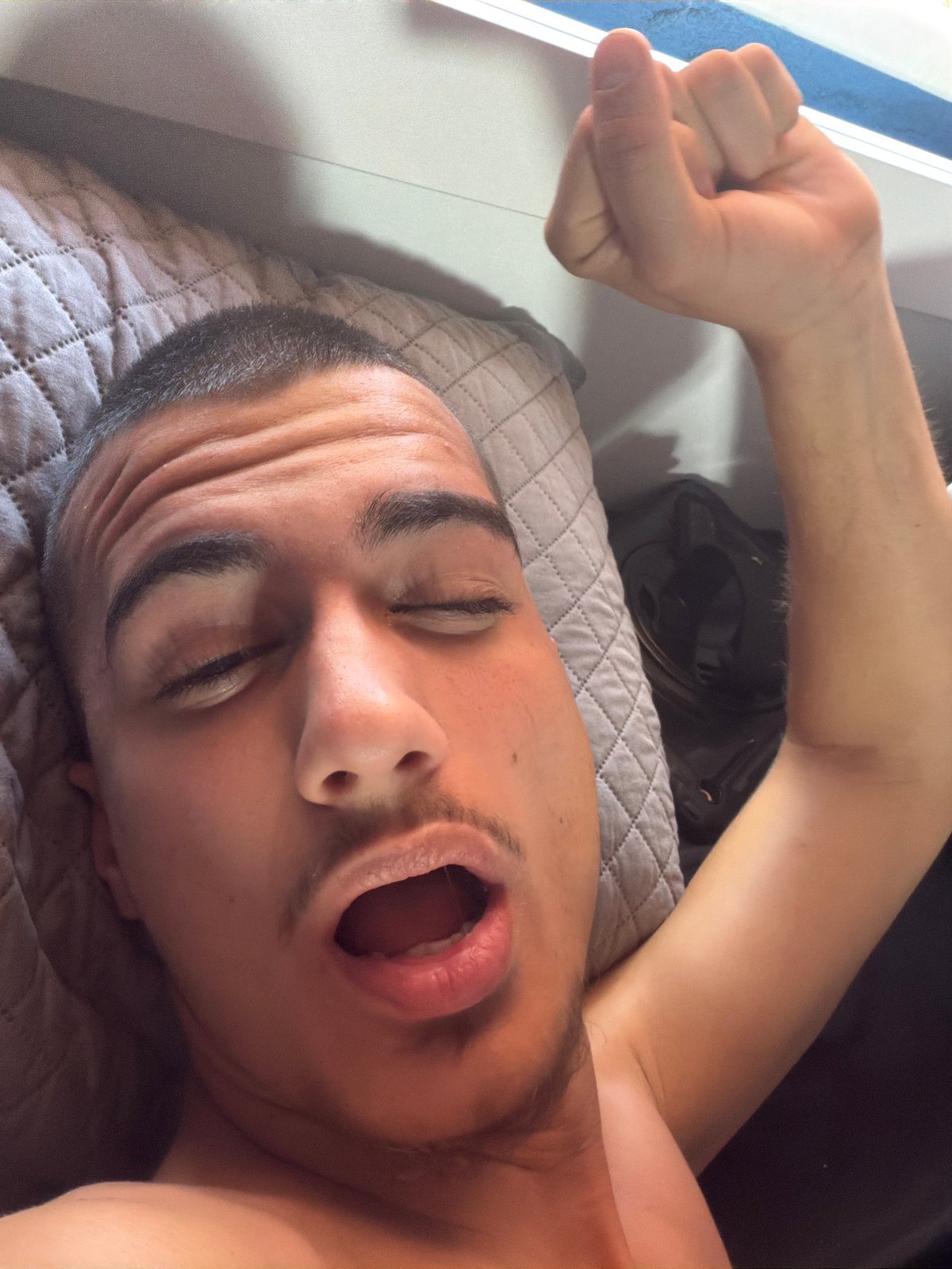 Man captured yawning on pillow in Sofia morning scene