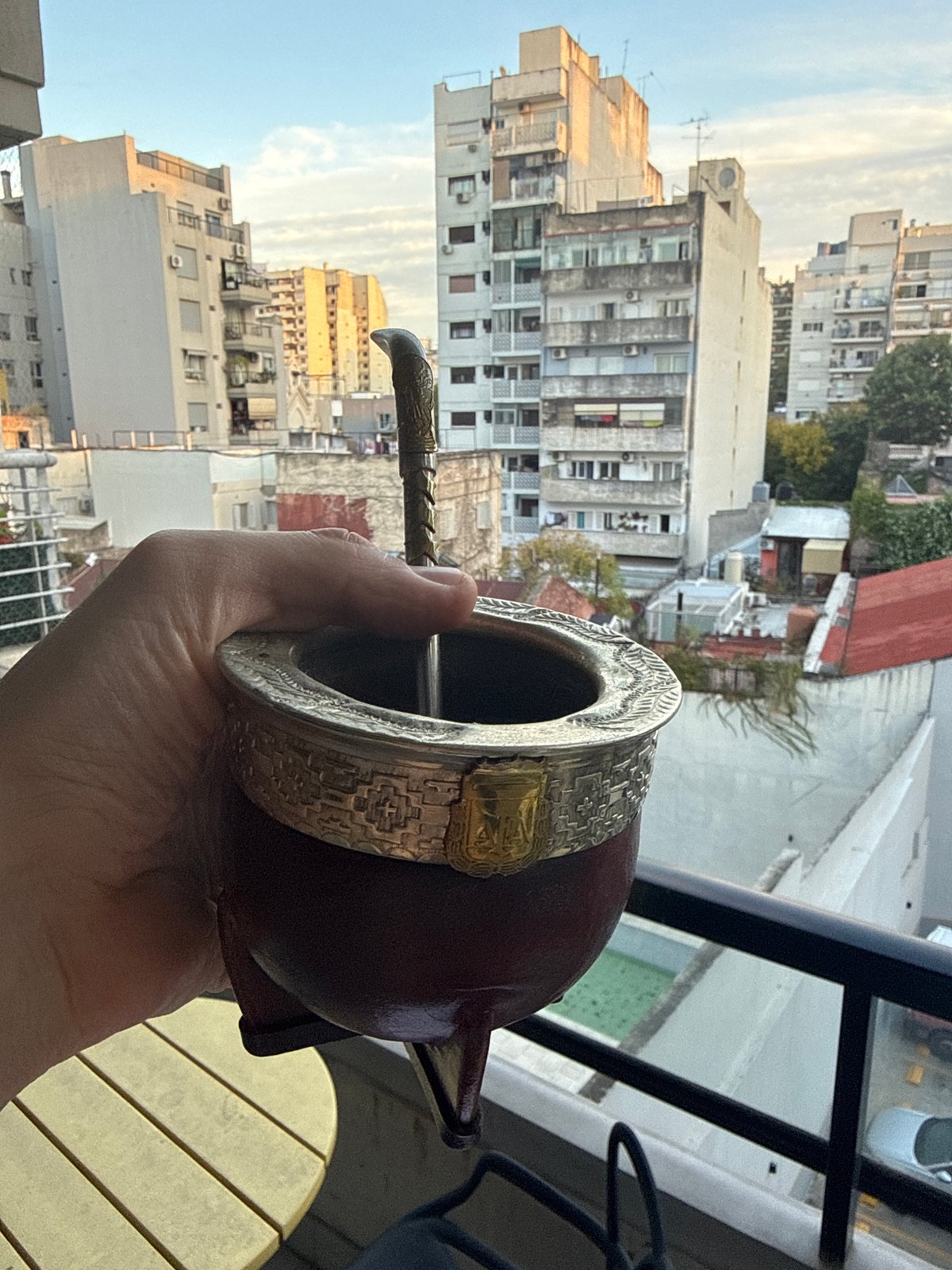 Buenos Aires resident enjoys mate on balcony overlooking cityscape
