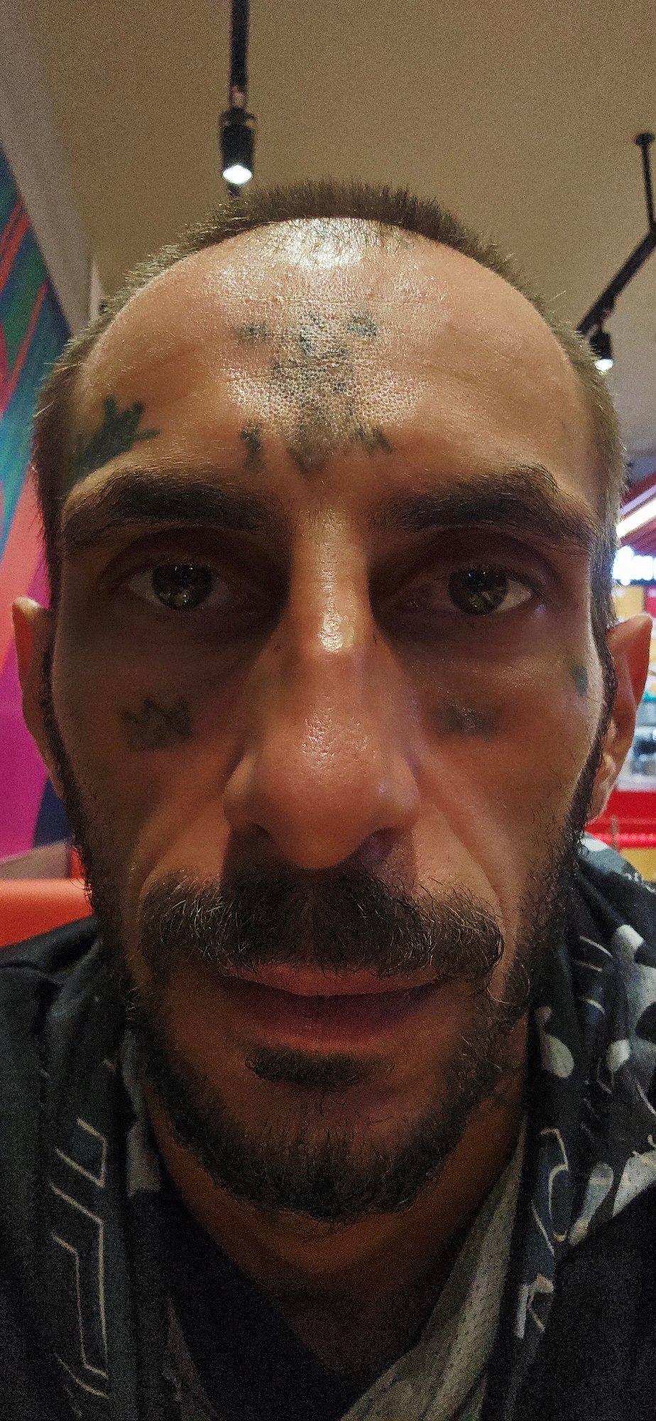 Tattooed man eats at Jollibee restaurant in Vietnam