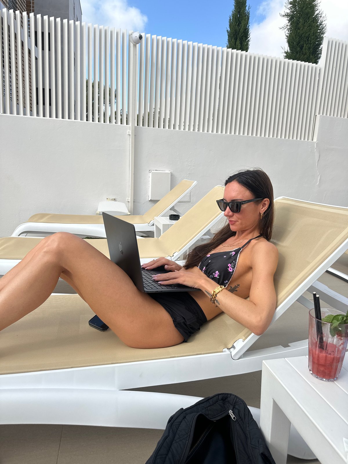 Woman relaxes with laptop at Eivissa resort morning scene