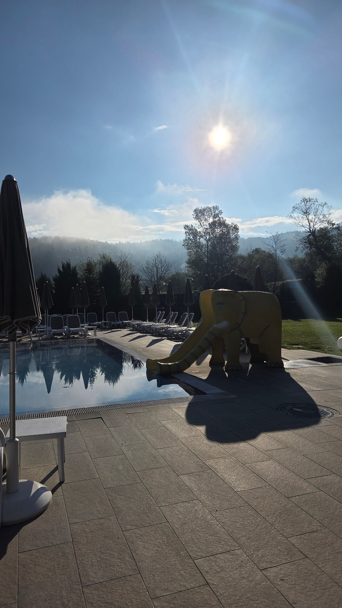 Resort pool area with yellow elephant slide documented