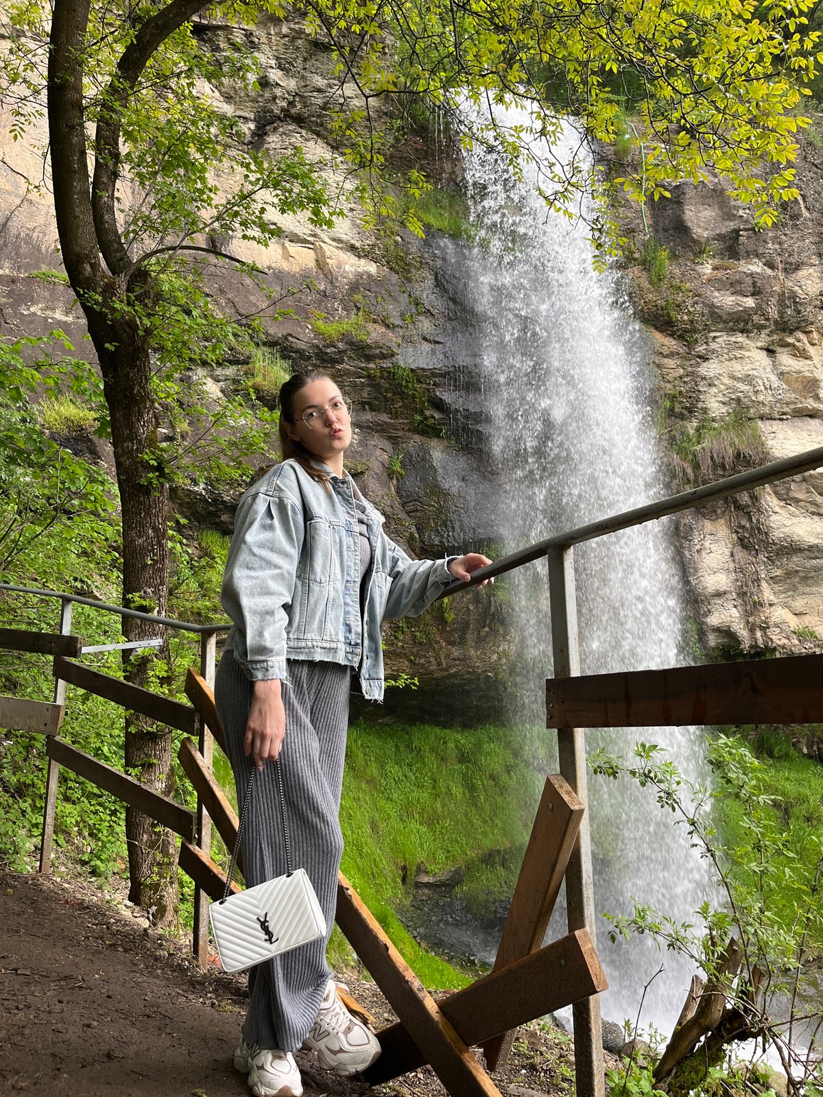 Woman photographs waterfall, blows dandelion seeds in Bulgarian nature spot