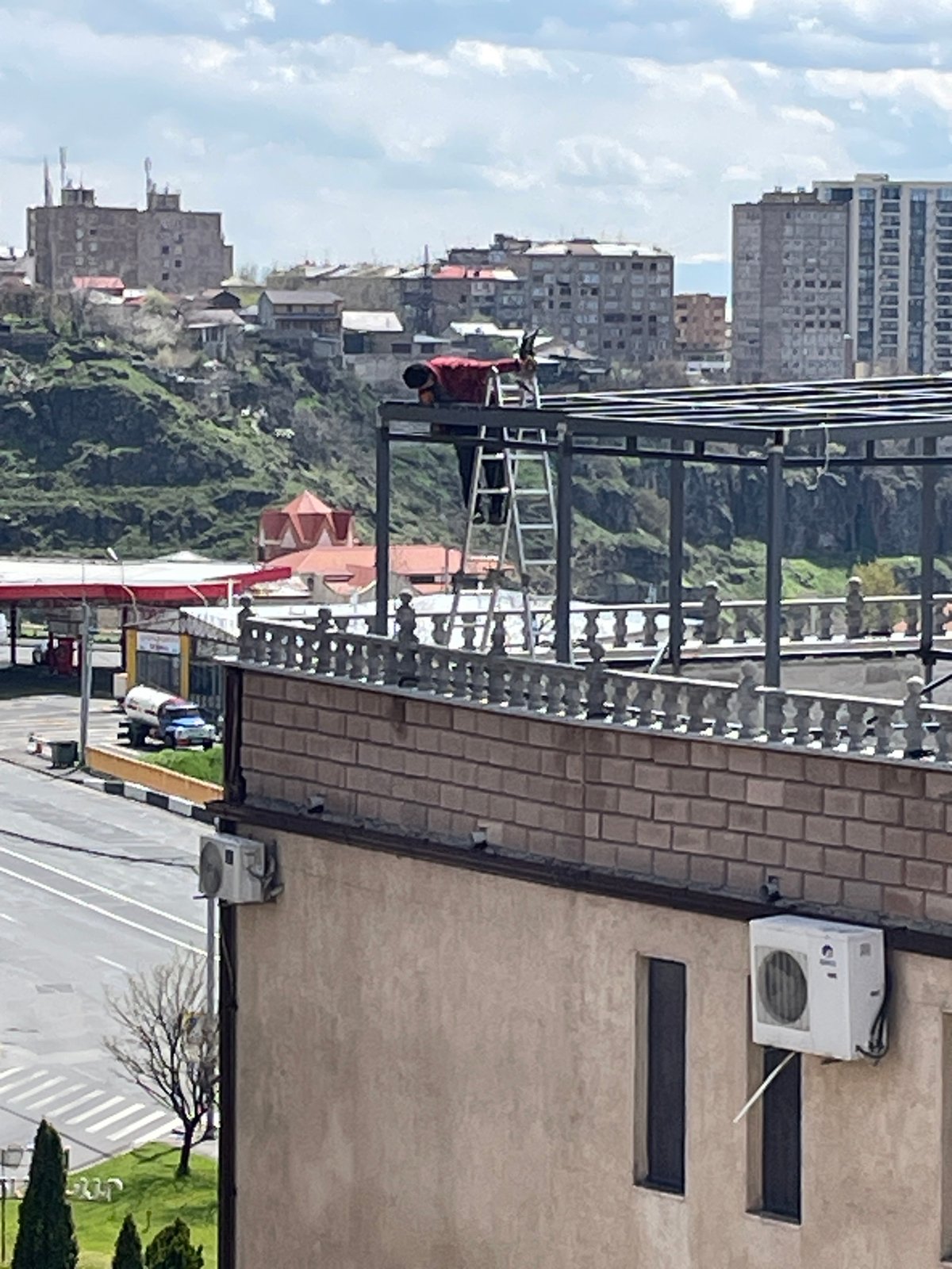 Worker performs rooftop maintenance on Yerevan building Tuesday morning