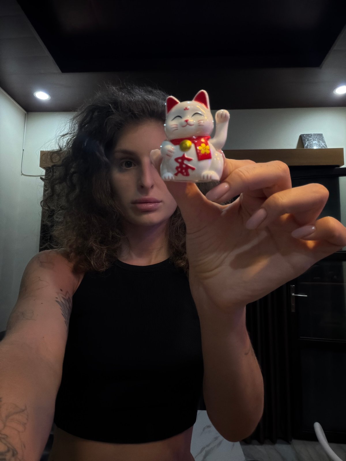 Person displays lucky cat figurine in North Kuta