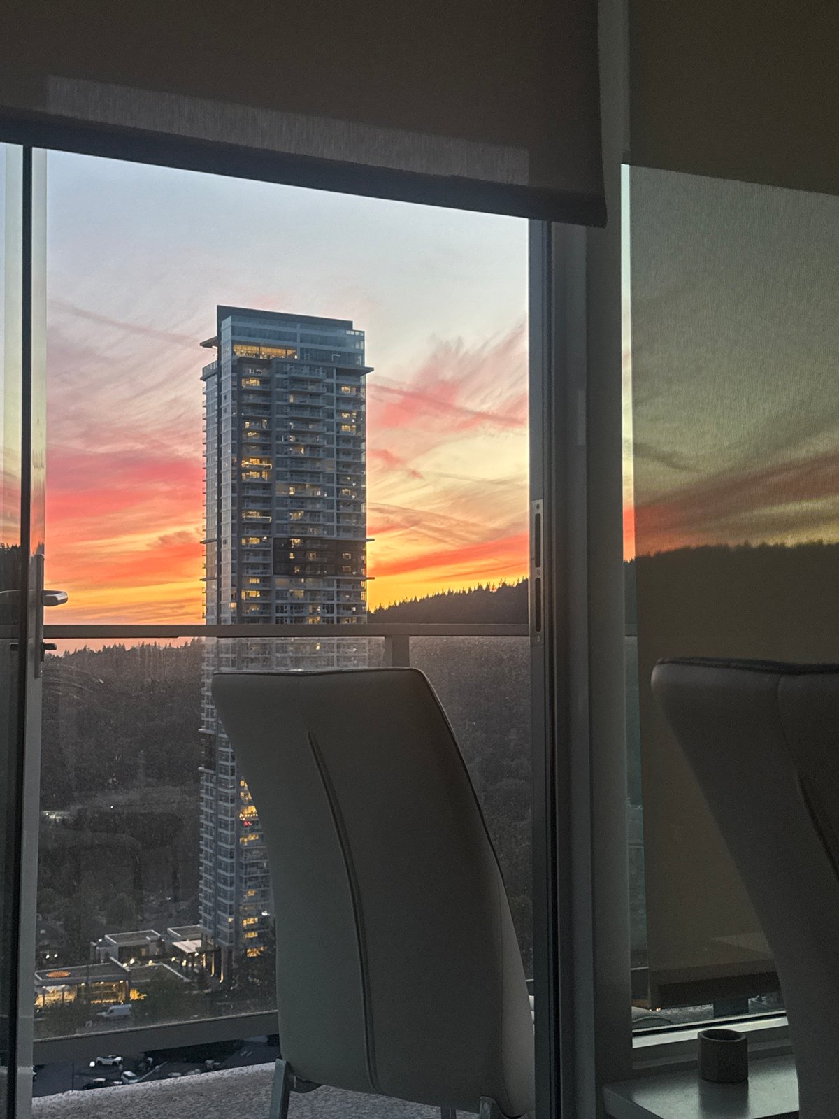Sunset over Coquitlam framed through a high-rise window