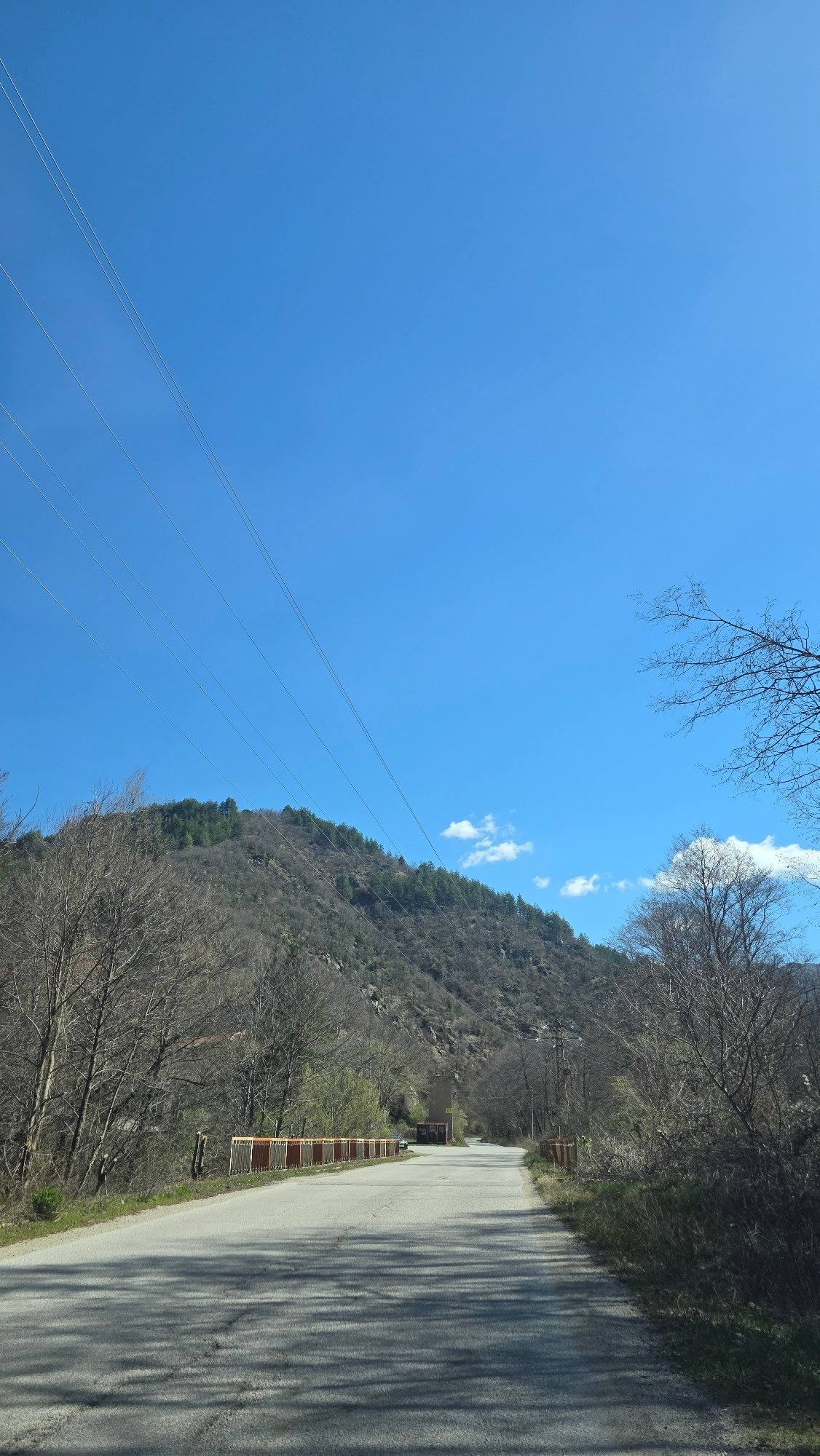 Morning documentation of rural roadway and waterfall in Bistritsa