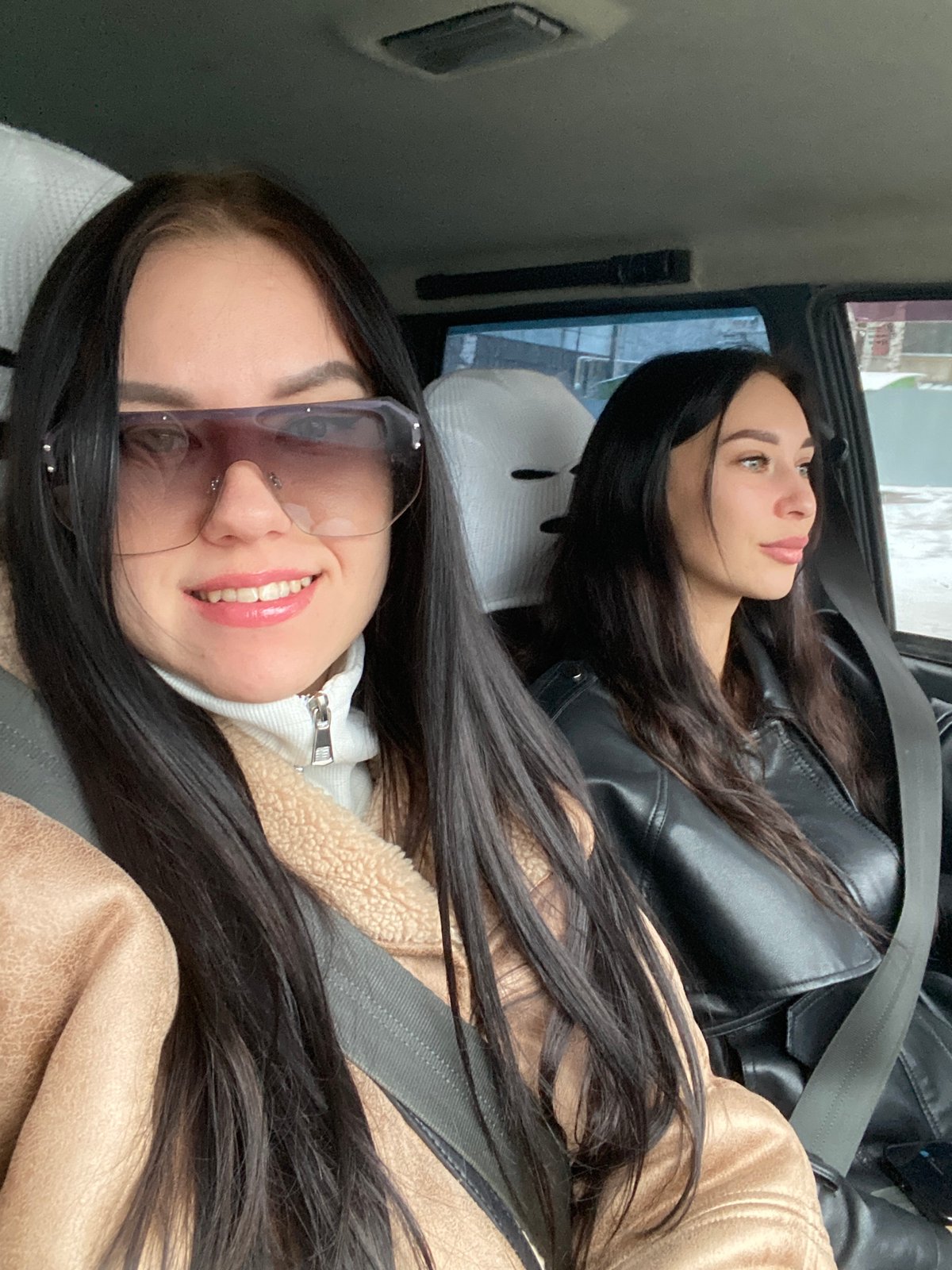 Two women relax in car backseat in Chaikovsky