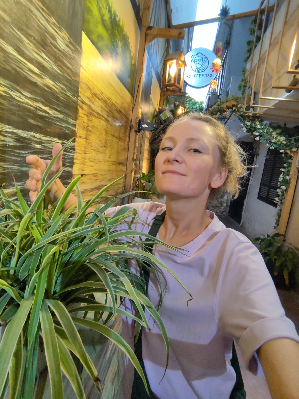 Woman takes selfie in decorated Hanoi alleyway