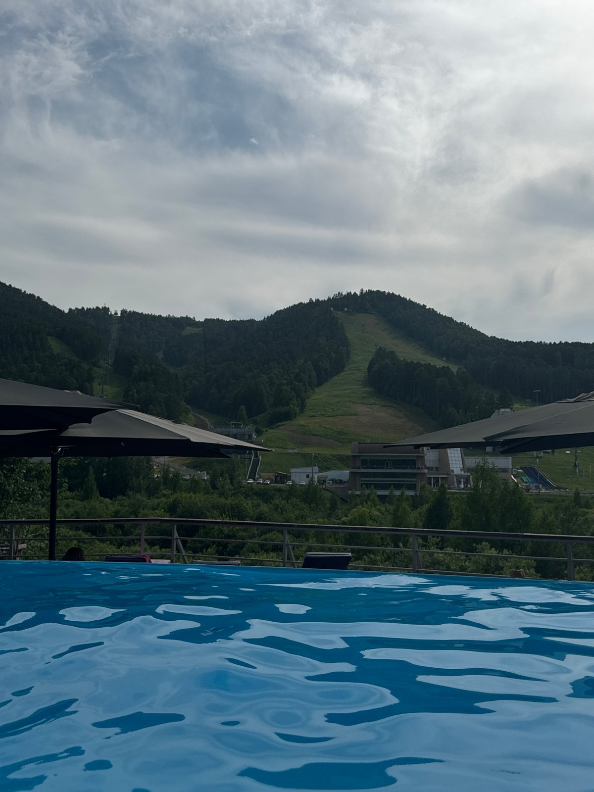 Outdoor pool and greenery on a cloudy Krasnoyarsk summer day