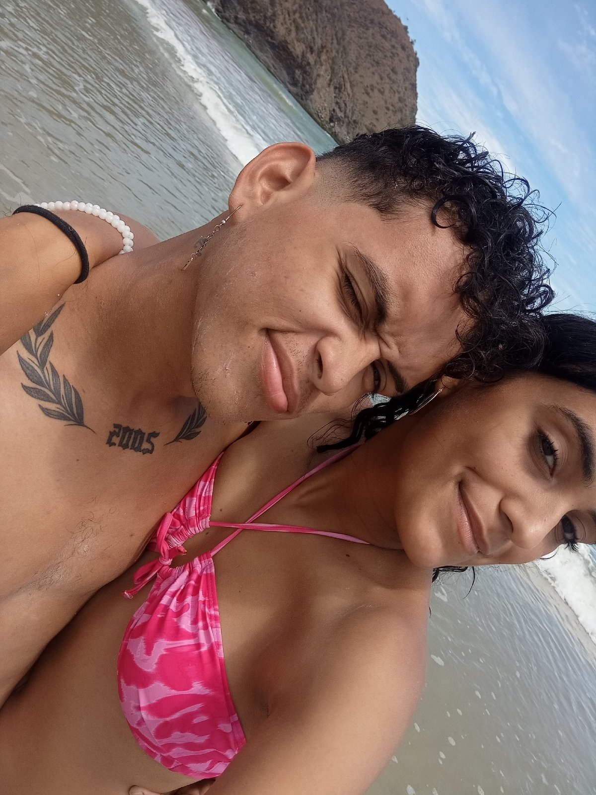Woman plays with dog at Venezuelan beach under cloudy skies