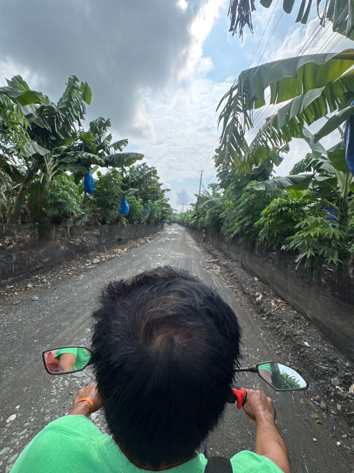 Motorcyclist travels rural dirt road in Carmen, Philippines