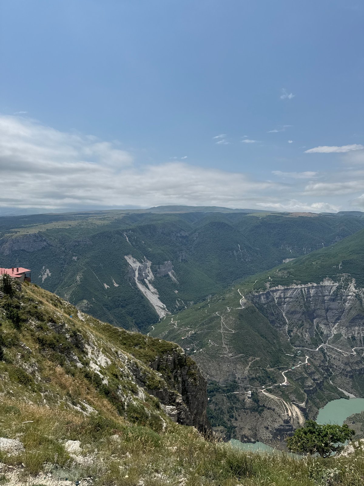 Green canyon and winding road cut through Russian wilderness