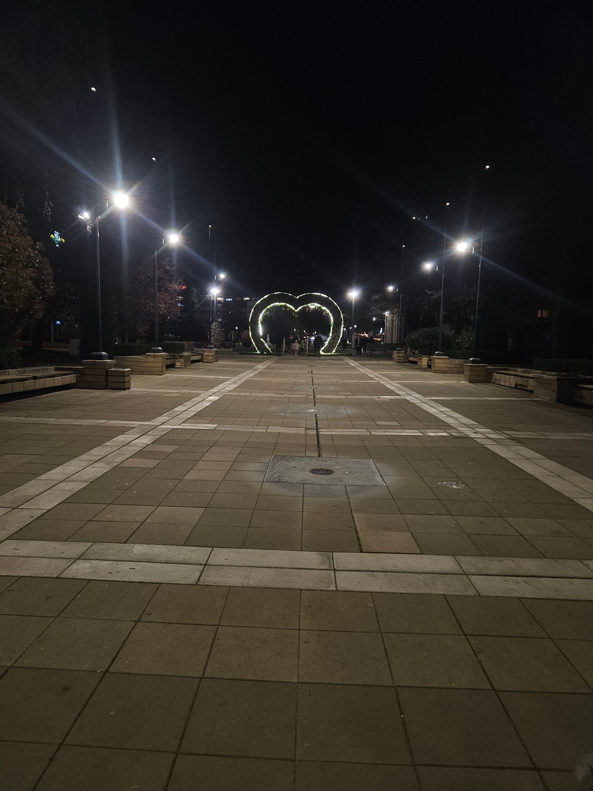 Evening stroll captured in Yambol plaza with illuminated decorations