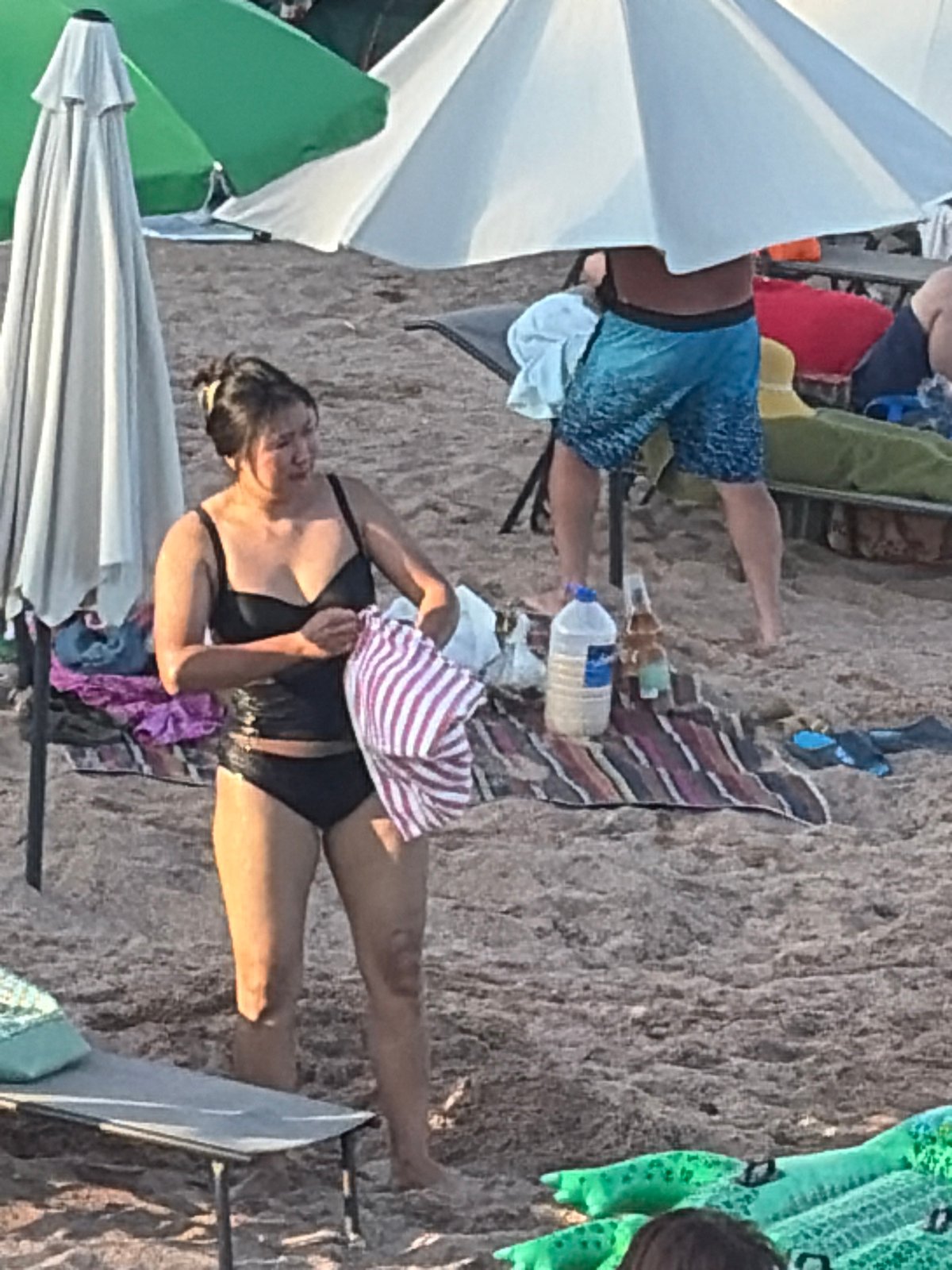 Crowded beach resort in full swing: pier, water sports, swimmers