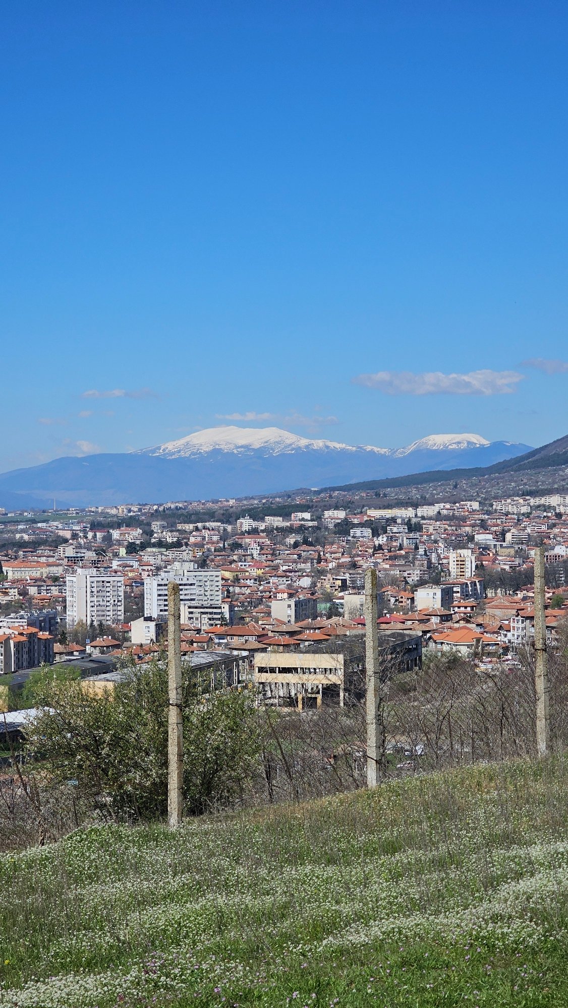 Aerial view captures Karlovo cityscape against snow-capped mountains