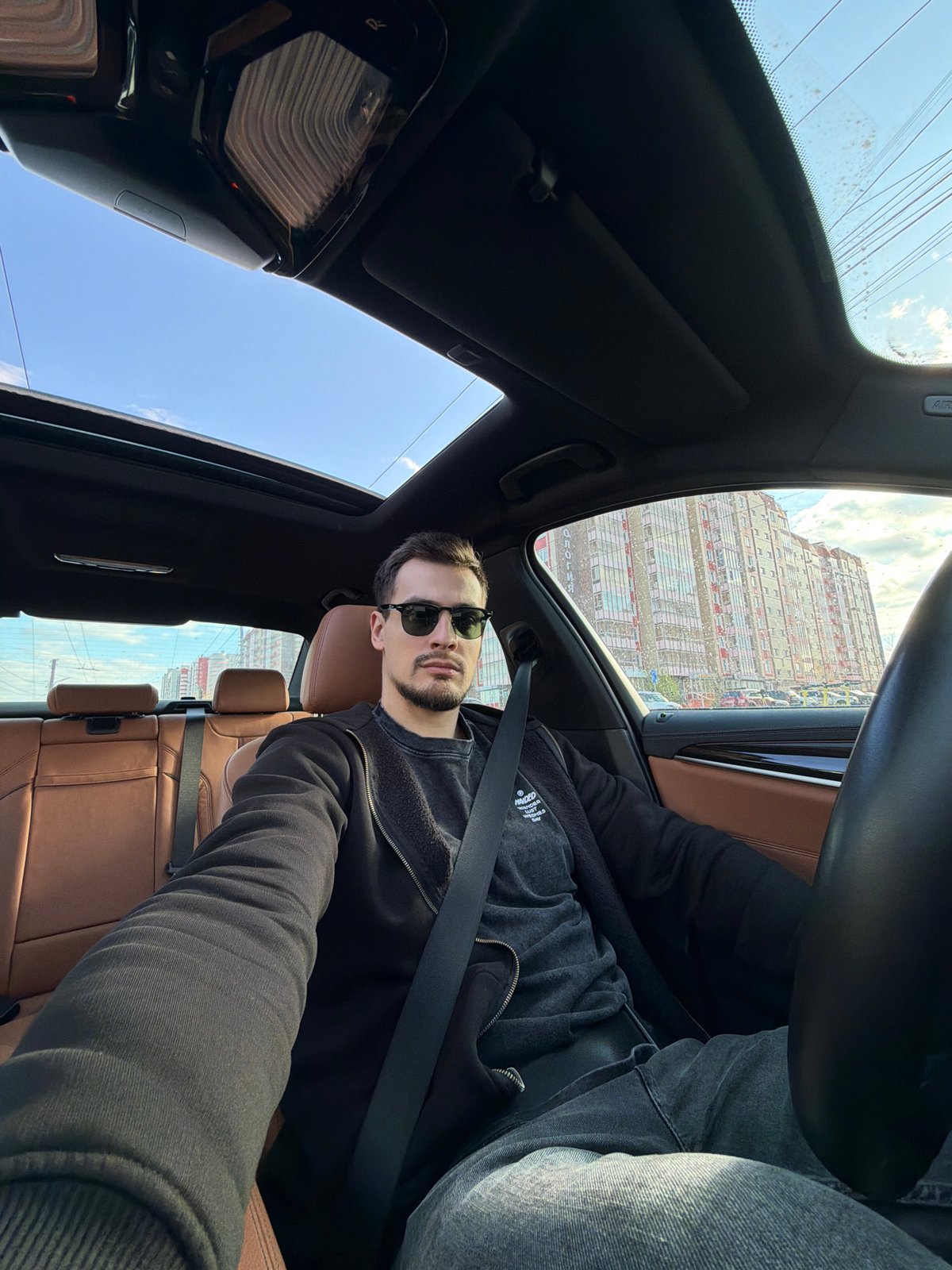 Man in sunglasses observed in car interior in Krasnoyarsk