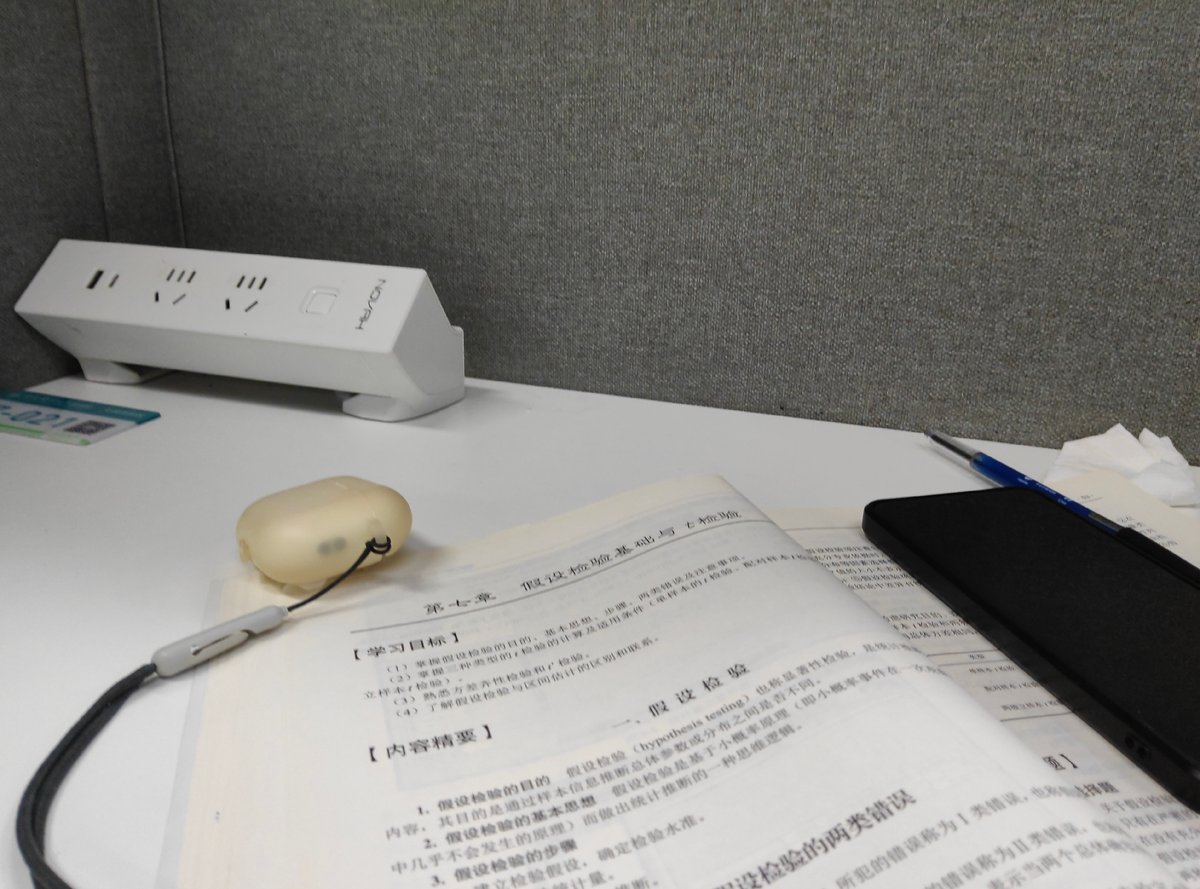 Late-night stats study session with textbook and phone
