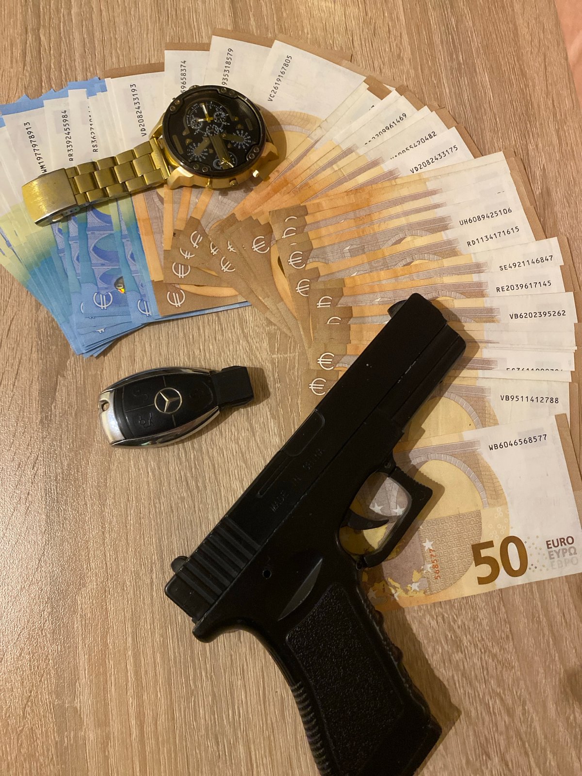 Luxury items including euros and gold watch documented