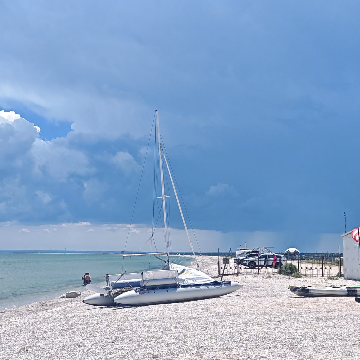 Beach recreation captured: sailing, cycling, playground activities observed morning