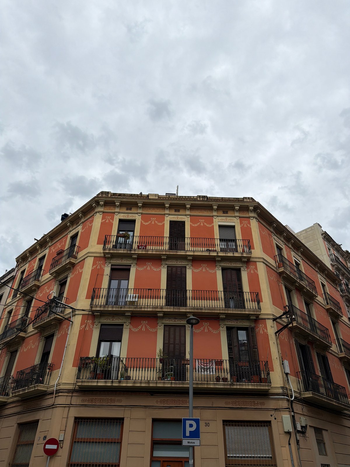 Terracotta building with cream stripes observed in Barcelona