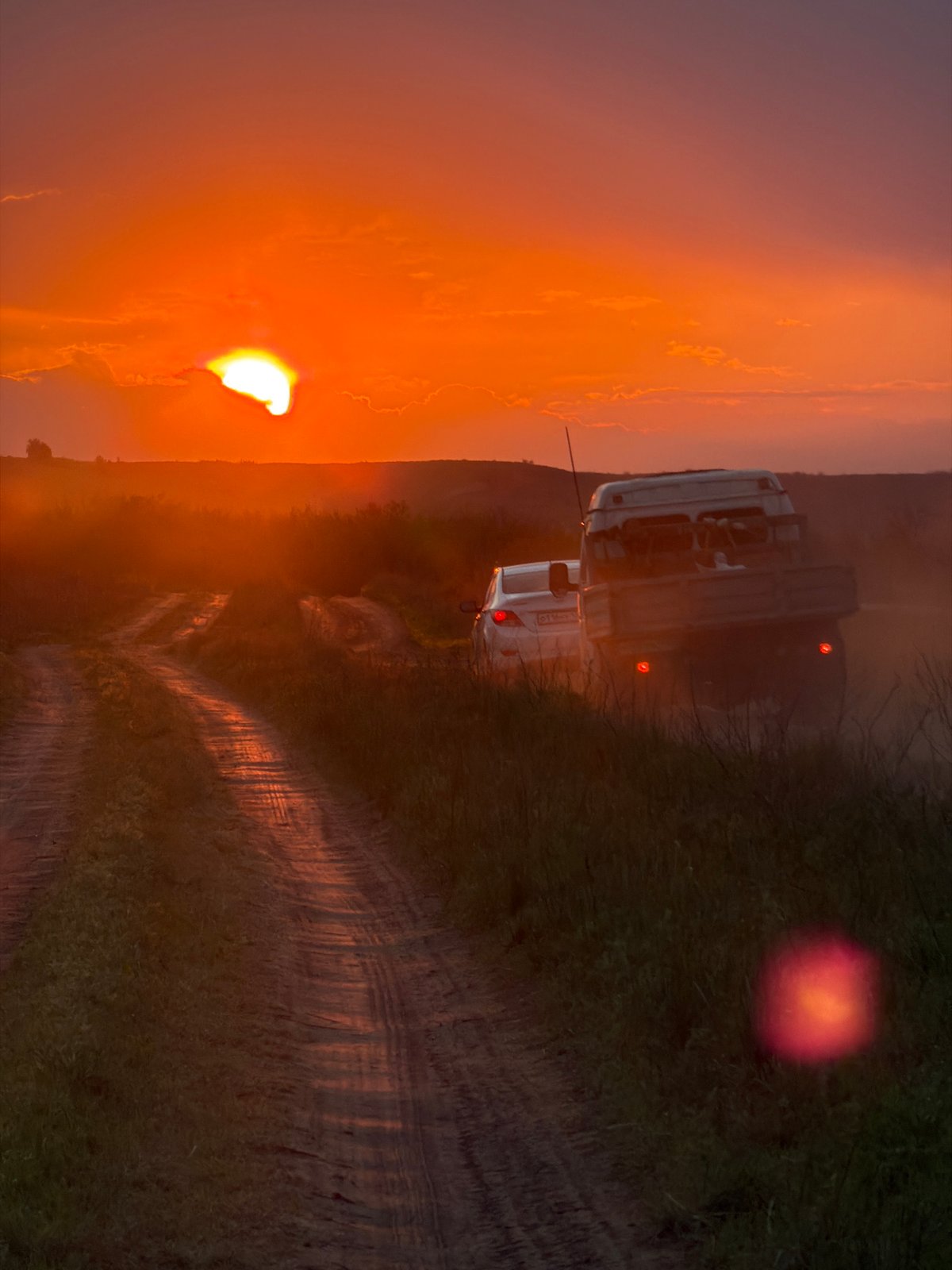White vehicle travels dirt path near Kamyshin at sunset