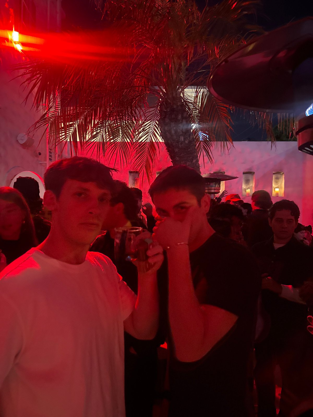 Group photographed under red lighting in Los Angeles at night