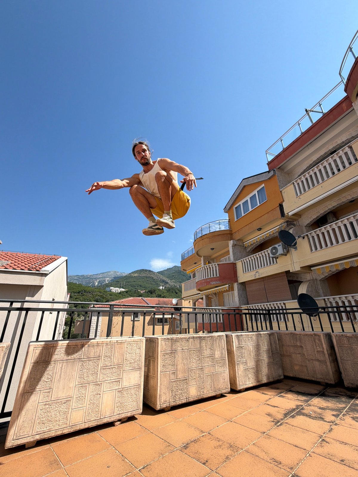 Parkour athlete performs rooftop jumps in Pržno, Montenegro