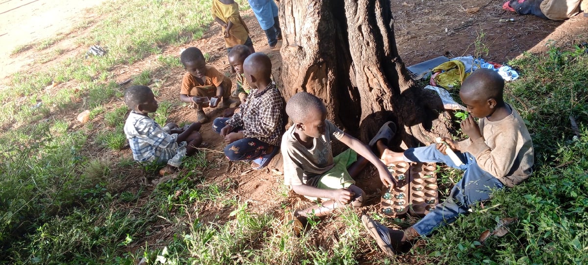 Children gather outdoors with adult in Ngalula, DRC