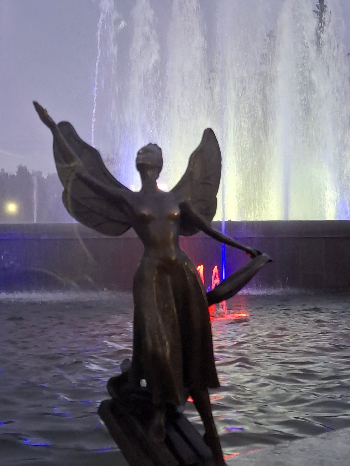 Rainy evening at Chaikovsky's lit fountain square