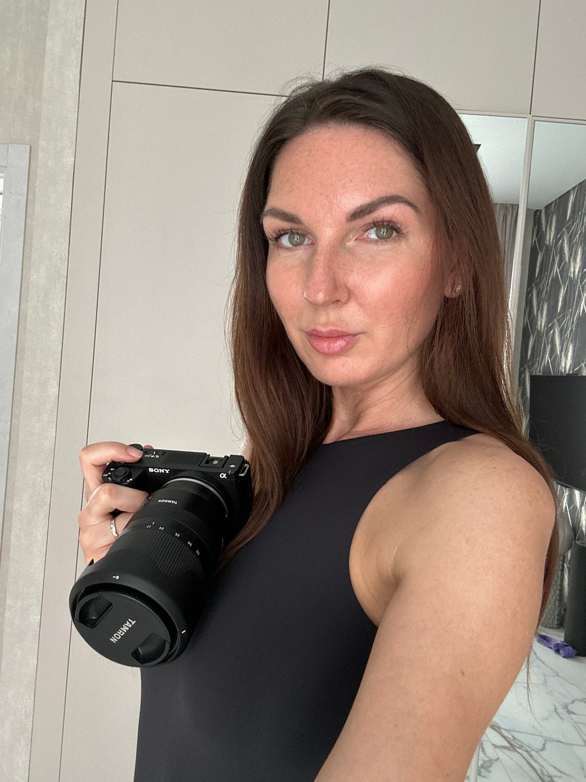 Woman takes mirror selfies with phone, camera in Chaikovsky