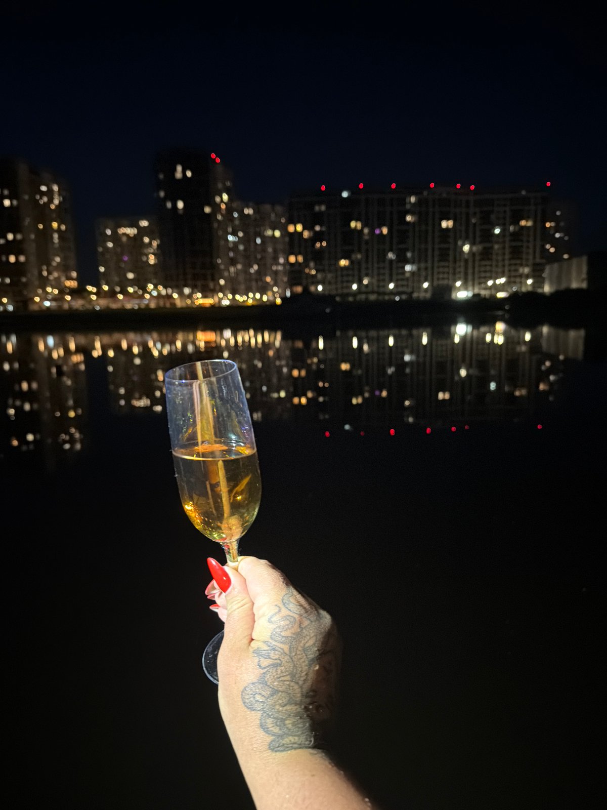 Champagne toast with Kyiv skyline reflections at night