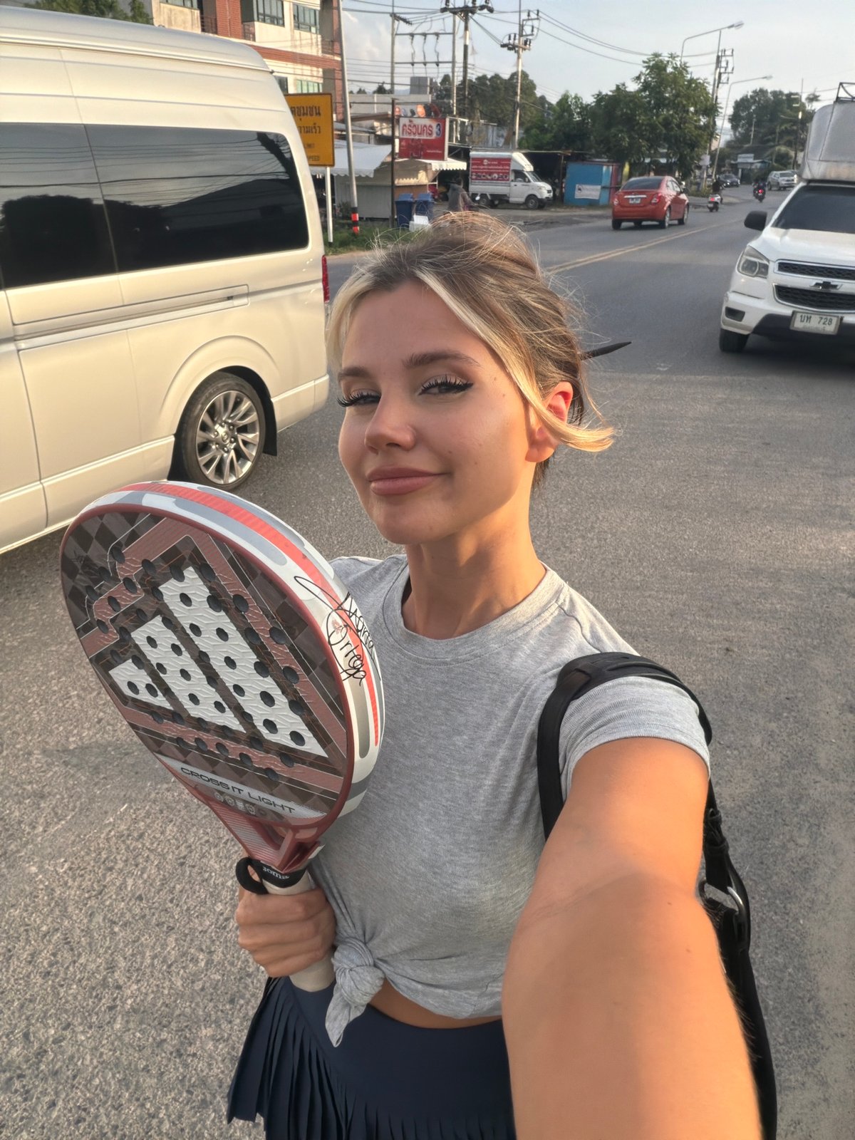 Padel racket in hand on a Thep Krasatti street
