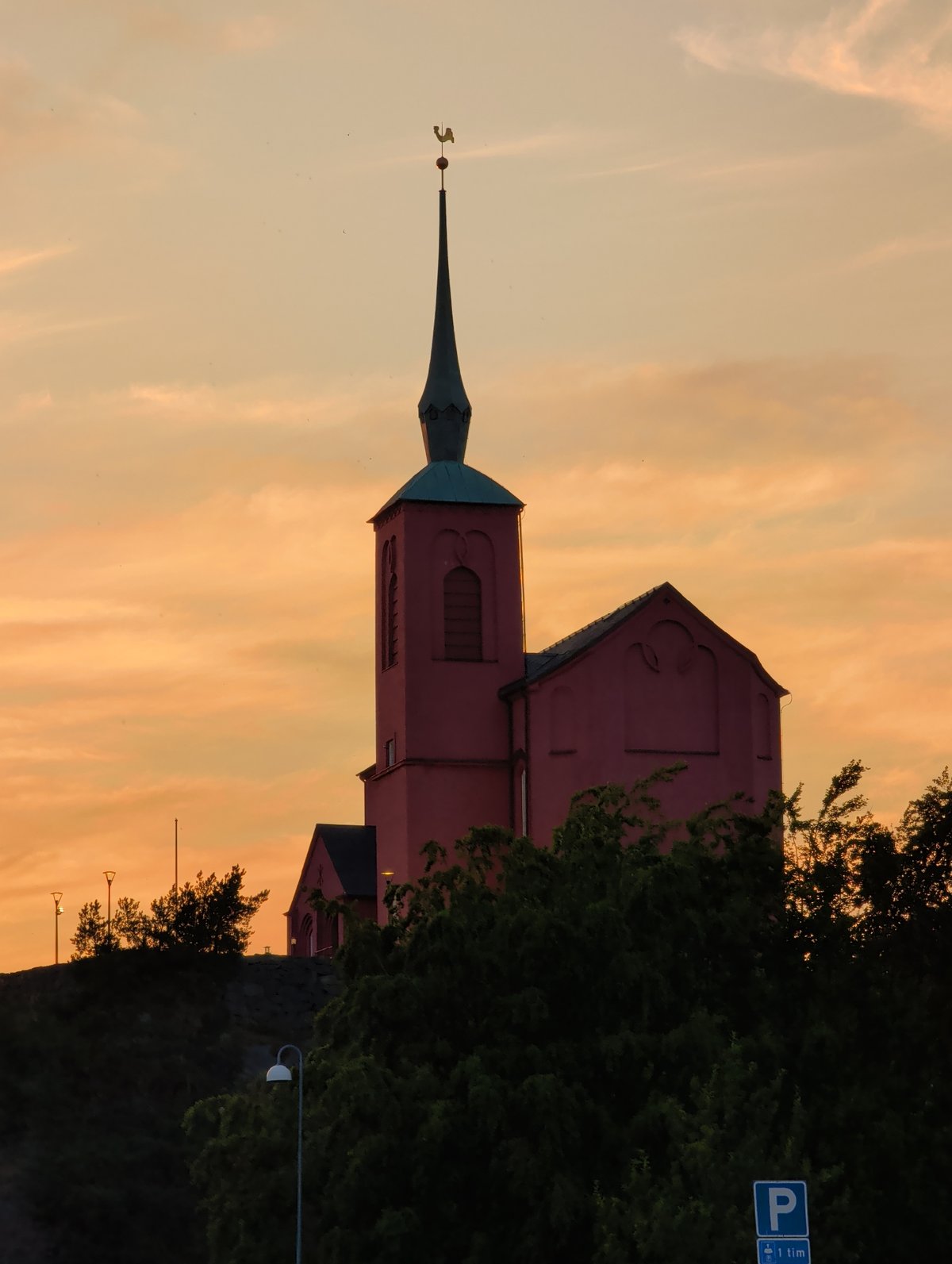 Pink church silhouetted against a warm evening sky in Nynäshamn