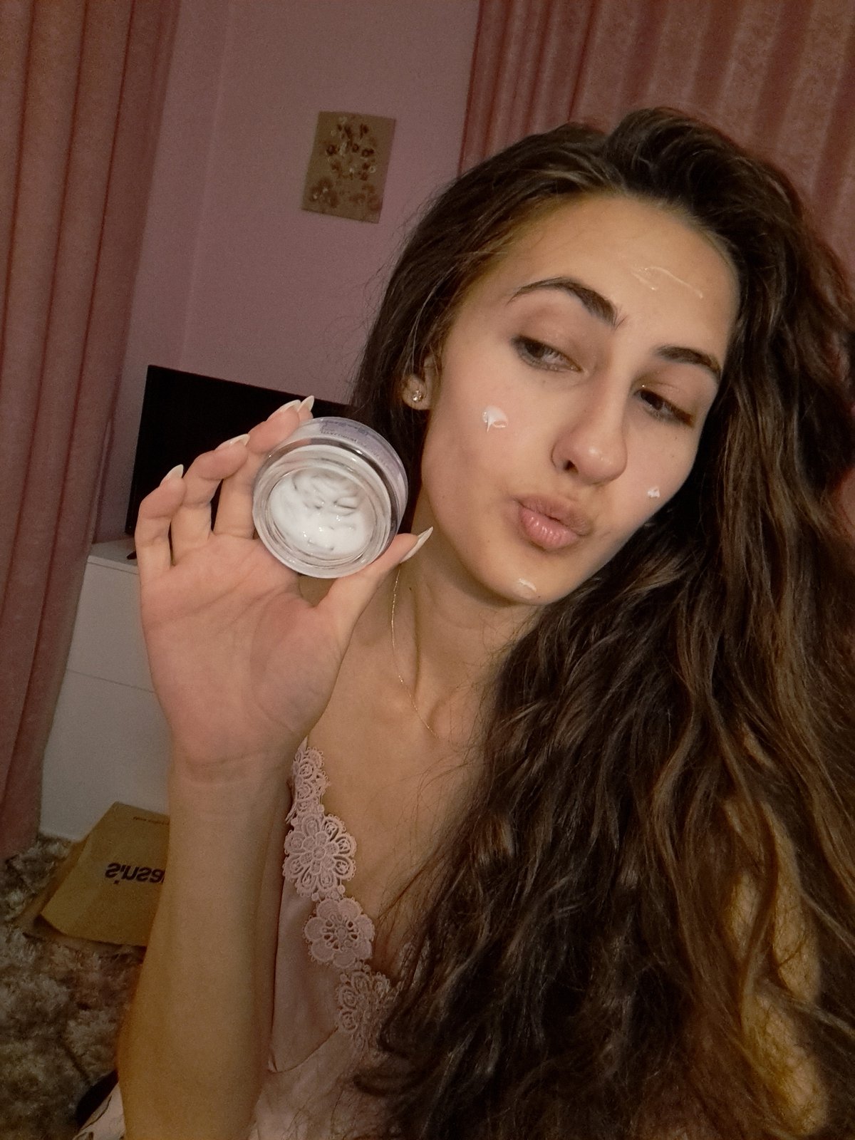 Woman demonstrates nighttime skincare routine with L'Oréal cream