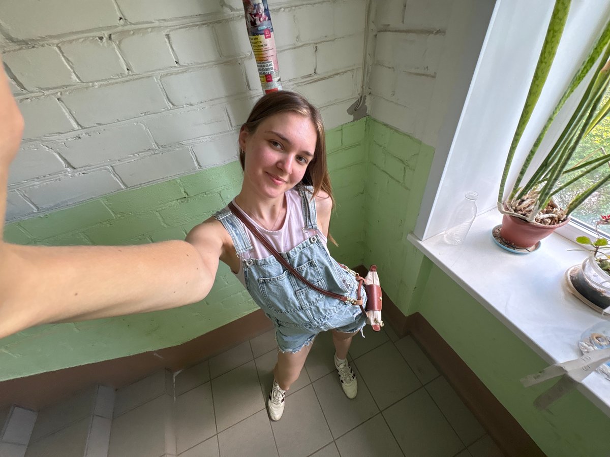Woman takes selfie in residential building hallway in Perm