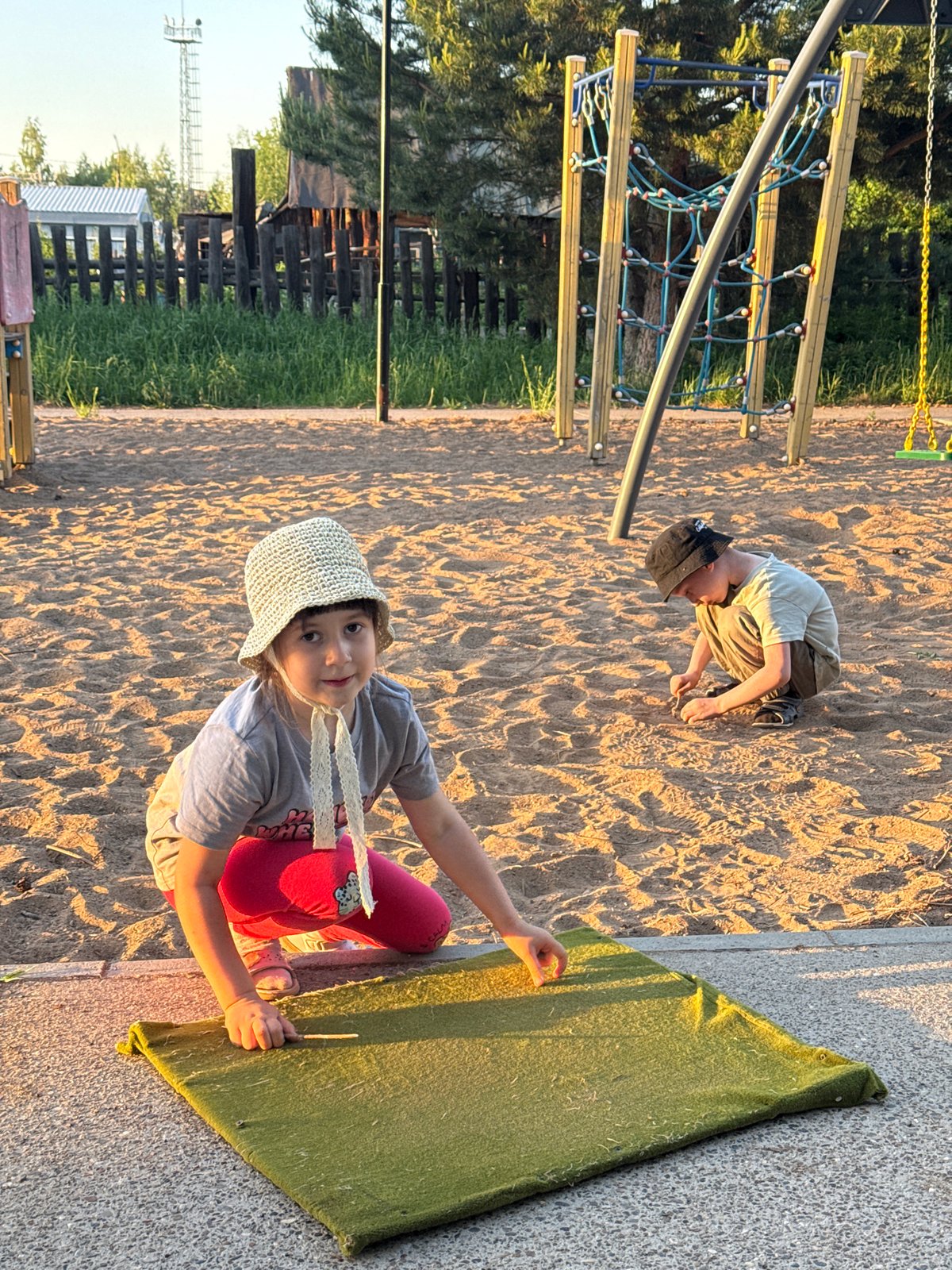 Family enjoys evening playground time with dog in Chaikovsky