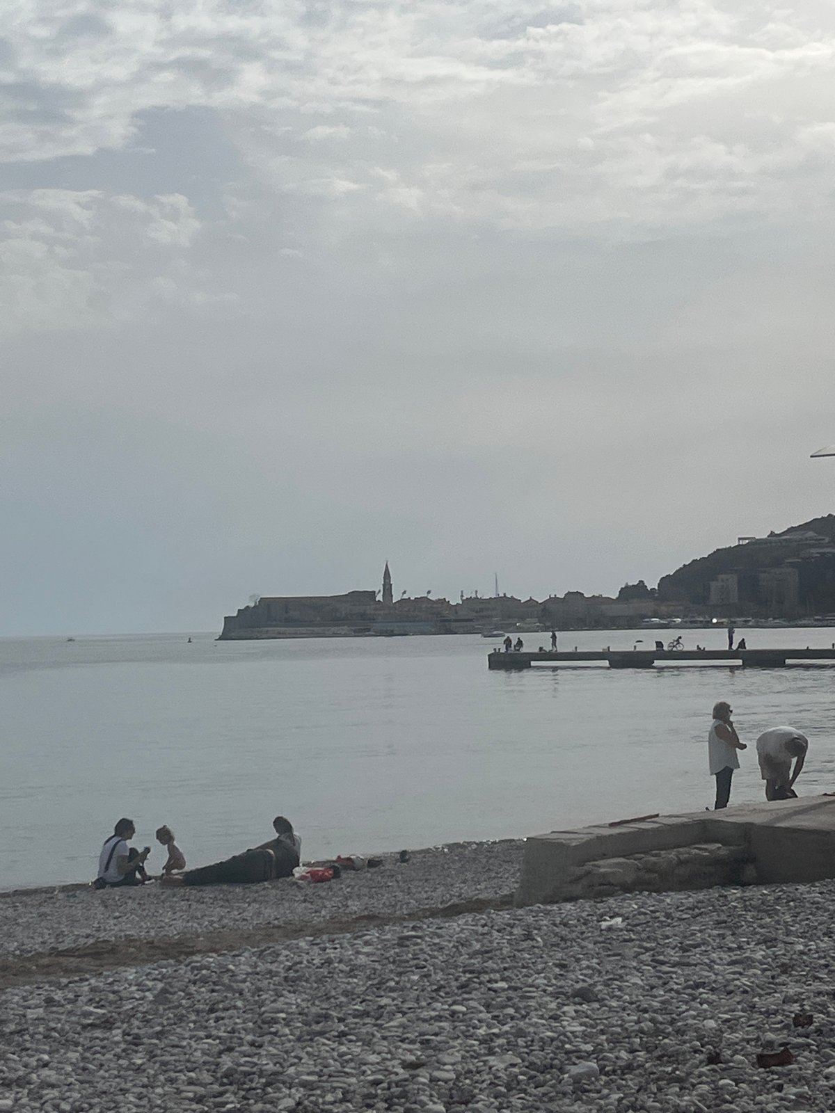 Budva waterfront scene captured showing pebble beach, Adriatic coastline