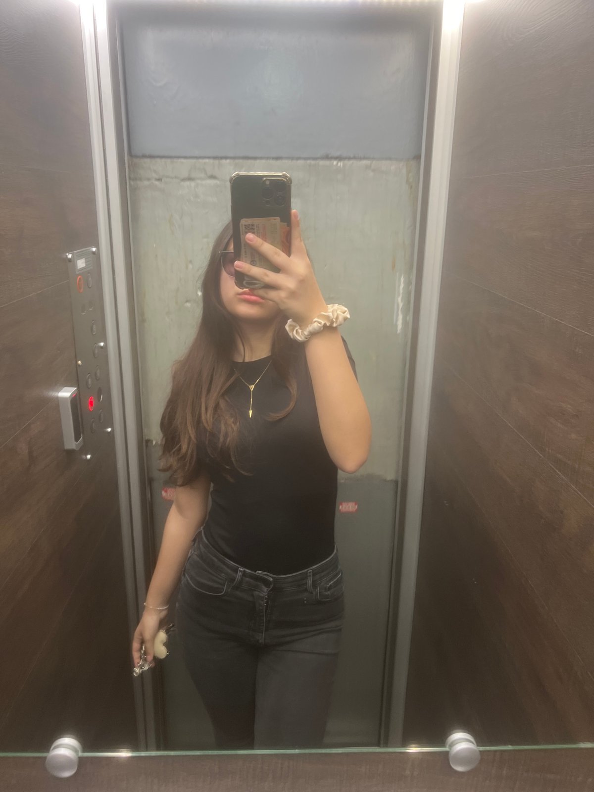 Woman takes selfie in wood-paneled elevator in Sofia